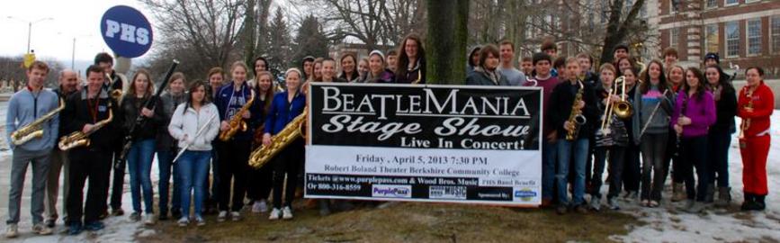 people holding their woodwind instruments with a banner beatlemania stage show in the middle