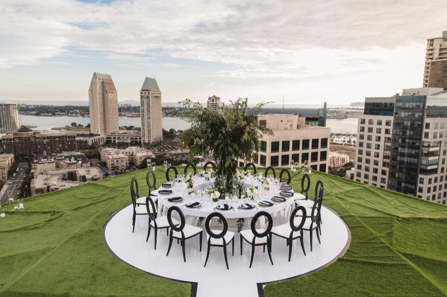 one large round white dining table and chairs on the rooftop
