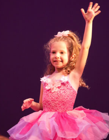 young girl wearing ballet outfit raised her left hand