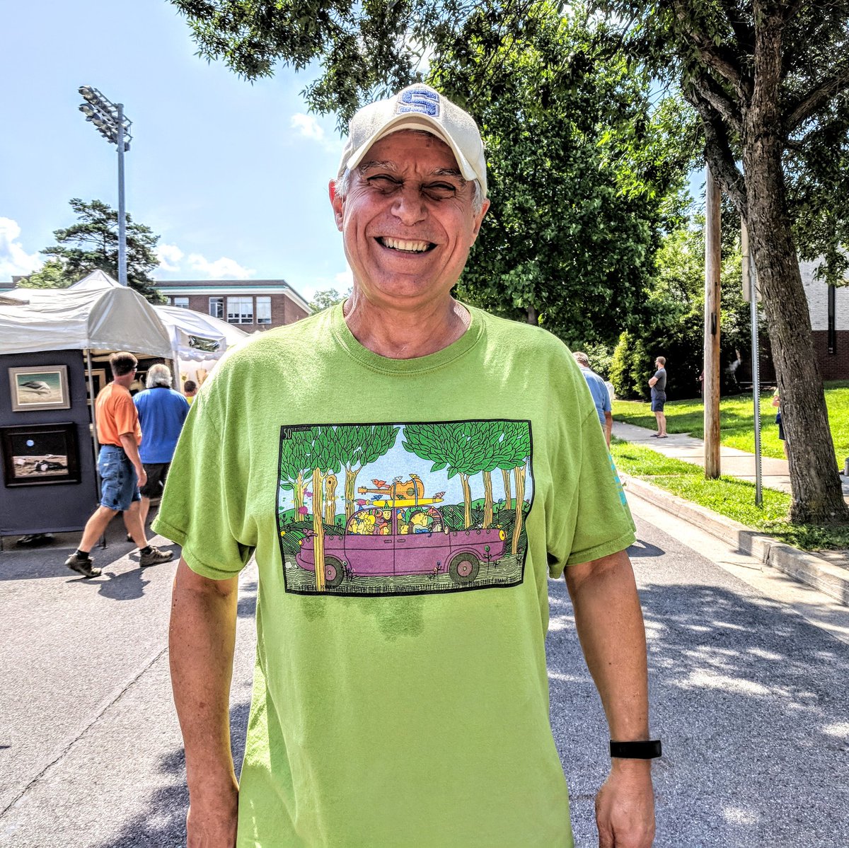 A smiling man wearing a green t-shirt for event.
