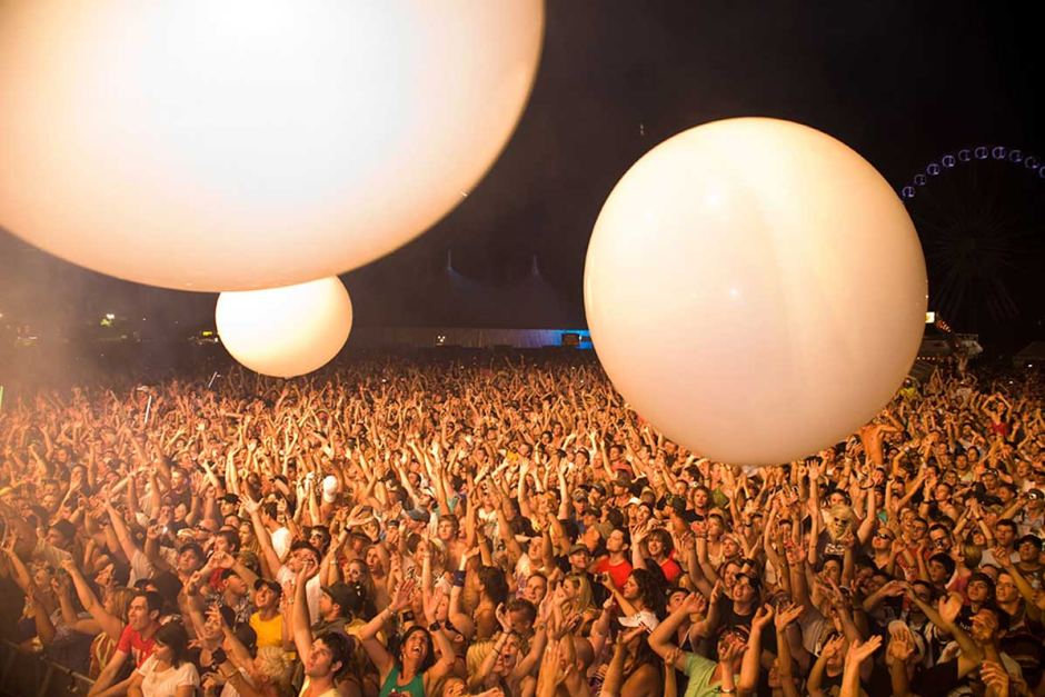 a large crowd tossing giant concert balloons