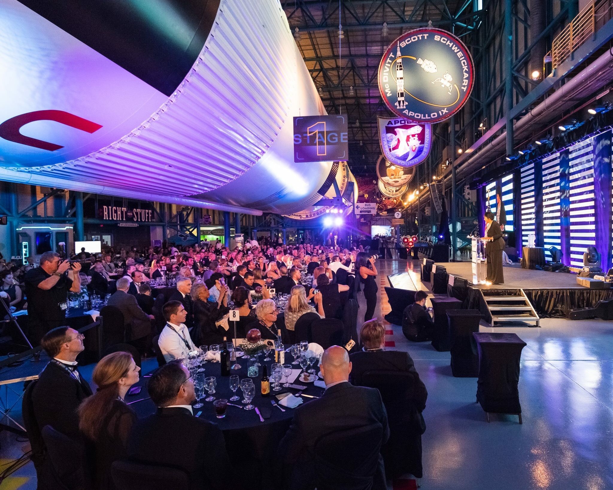 people sitting at tables with a rocket ship above them