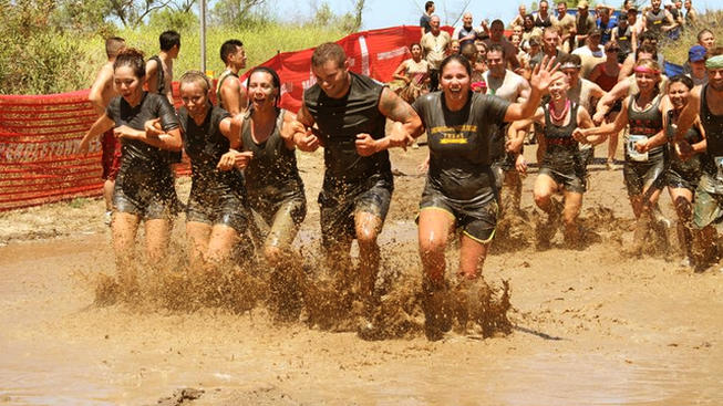 a group of people run/walk in a mud for a cause