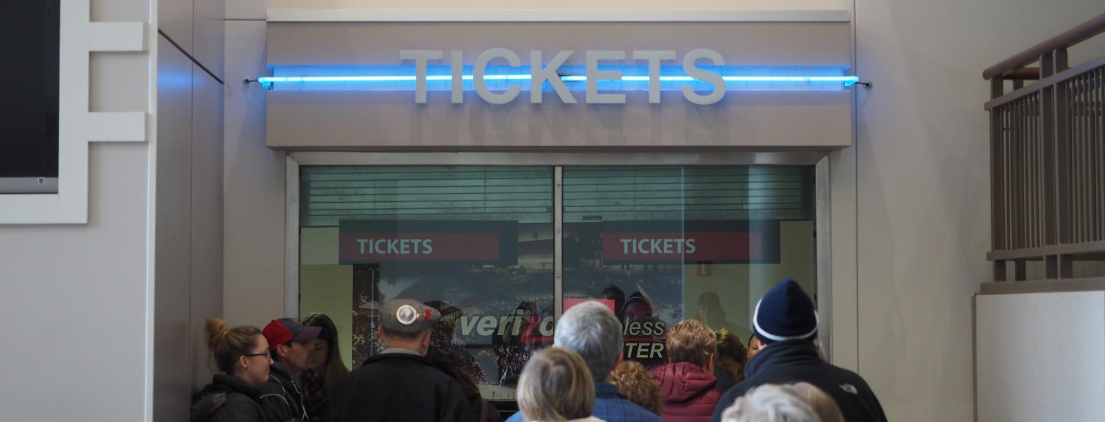 people buying tickets at the ticket booth