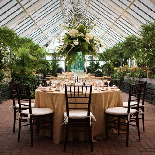 seating and table arrangements and an overhead bouquet of flowers at the center for an event