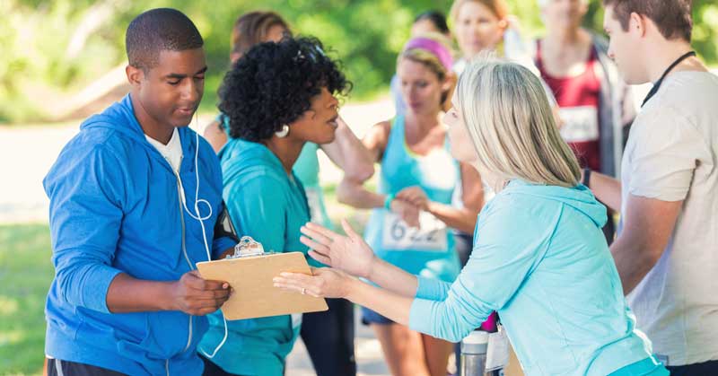 a man and a woman holding a paper while other people talking on the side