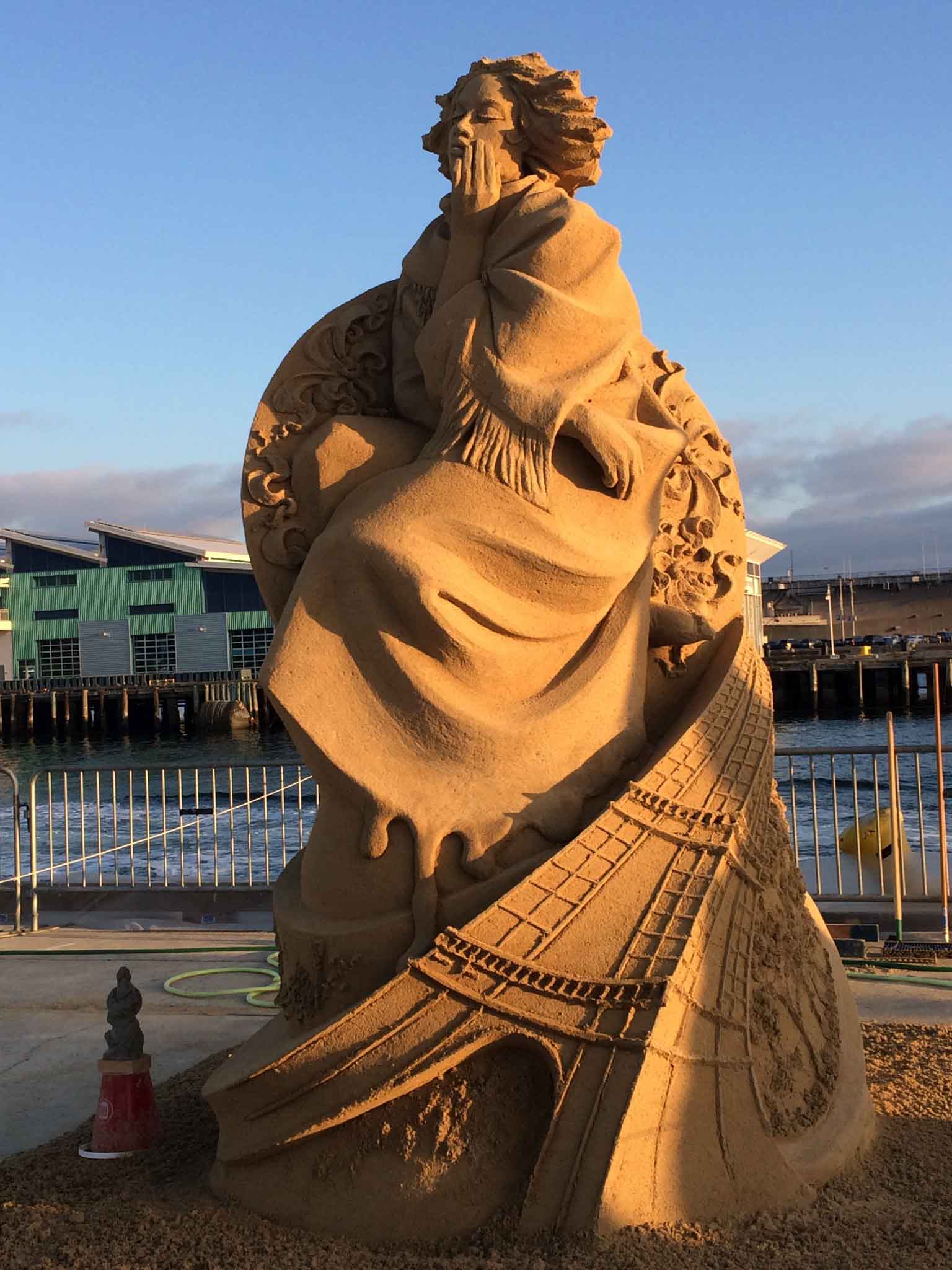 a woman sand sculpture illuminated at night