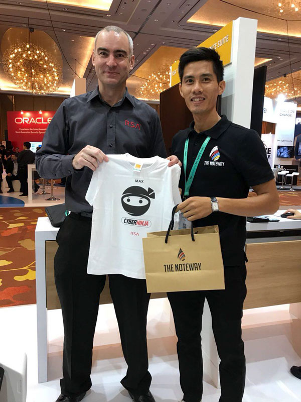 two men holding a printed shirt and a paper bag