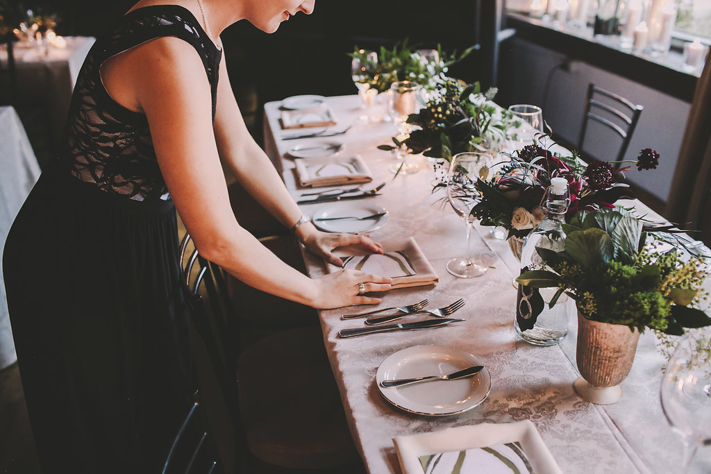 a woman doing table set up for an event