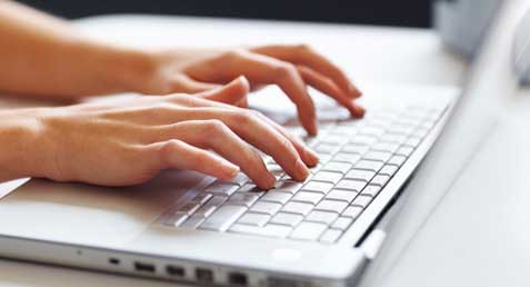 hands typing on laptop keyboard