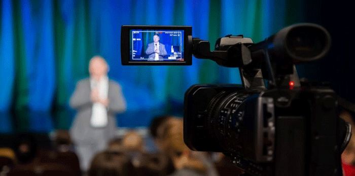a video camera used for a live video capturing a man speaking for a virtual event