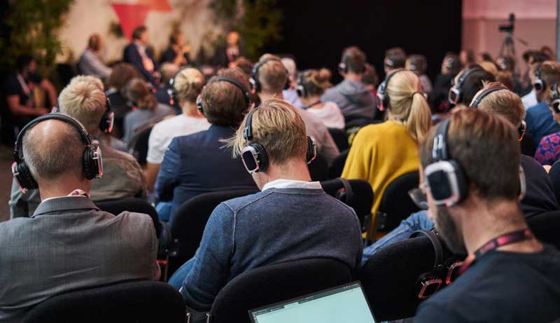 attendees of a conference wearing headphones