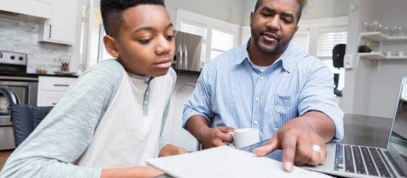 father helping son do homework