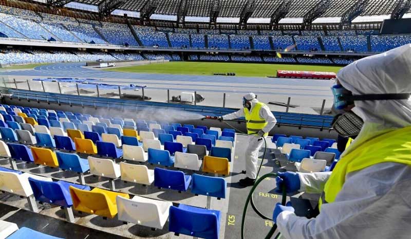 two people cleaning and disinfecting the stadium to prevent the spread of covid-19