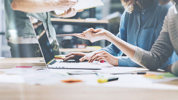 a picture of women hand pointing her ballpen in laptop