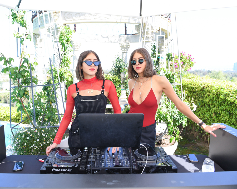 a twin dj influencer wearing glasses in their audio mixer
