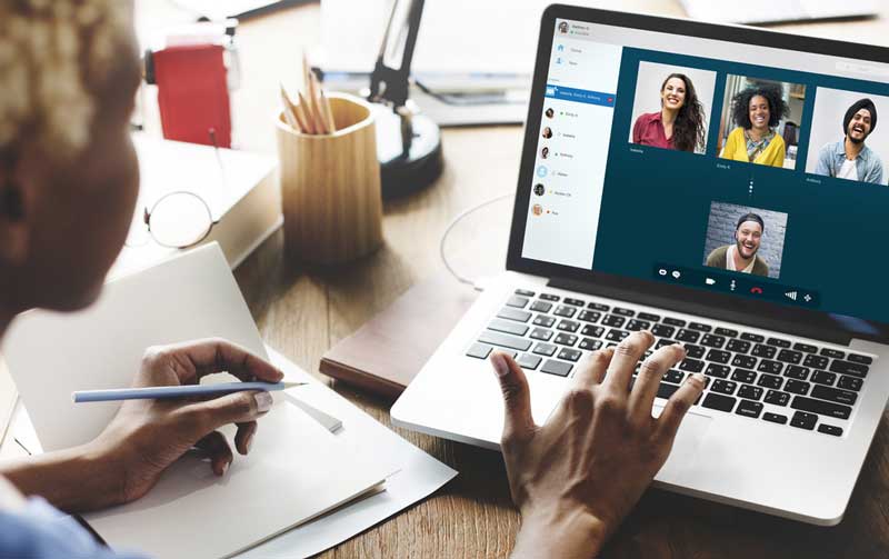 a woman having an online virtual team meeting with her co-workers