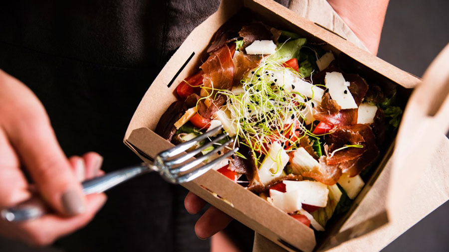 A cardboard throwaway container of asian food