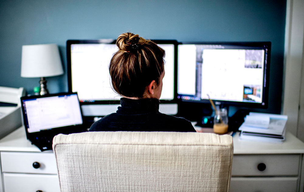 the back of a woman's chair and she is looking at the computer