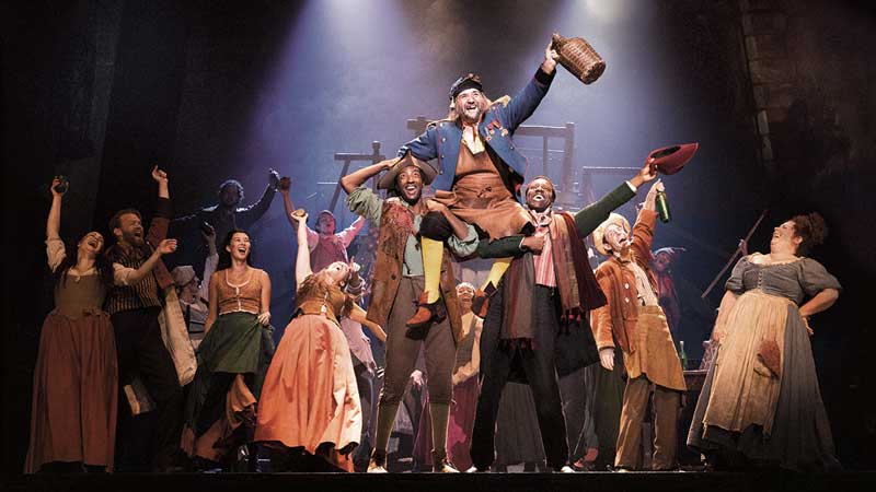 A cast of actors on stage in a theater production