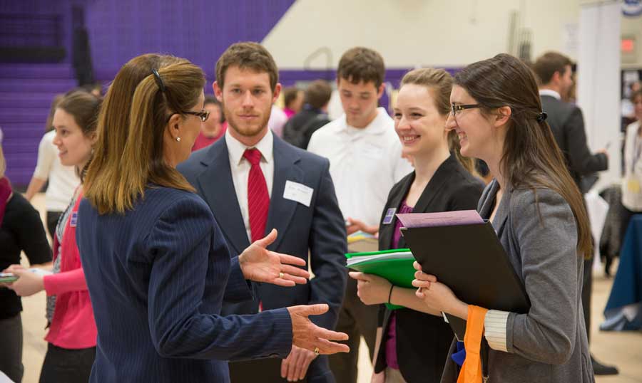 a-woman-talking-to-students-at-a-job-fair-in-college