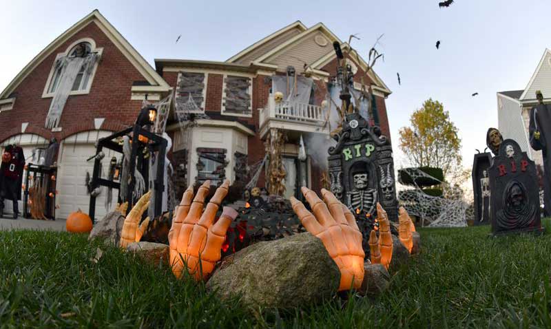 spooky-house-with-Halloween-decorations-and-hands-coming-out-of-the-ground