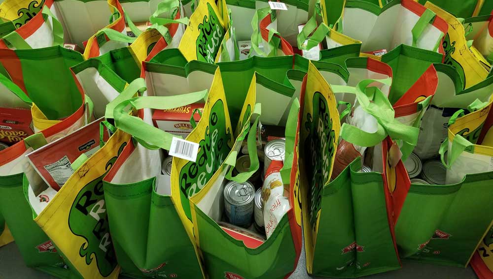 a-bunch-of-green-bags-with-food-in-them