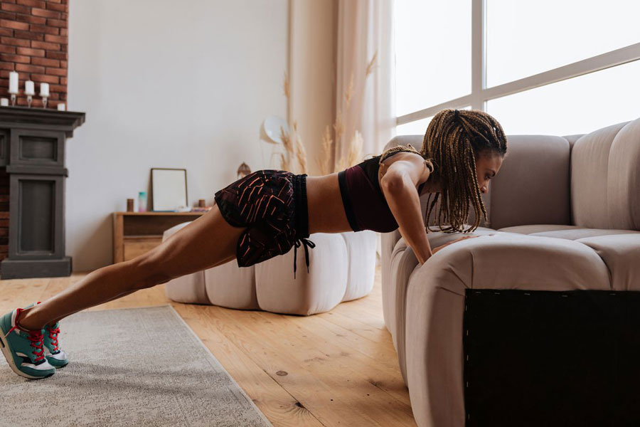 a-woman-doing-pushups-on-the-couch