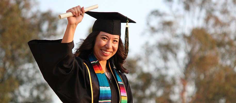 a-woman-holding-up-diploma-with-a-graducation-cap