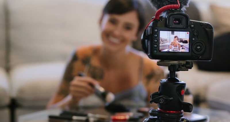 a-girl-filming-herself-painting-and-smiling