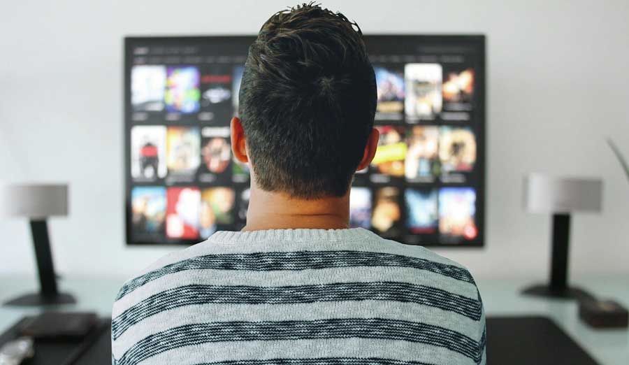 a-man-sitting-in-front-of-the-tv-on-netflix