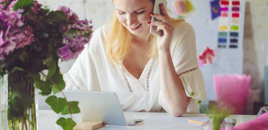 a-woman-on-her-phone-looking-at-a-computer