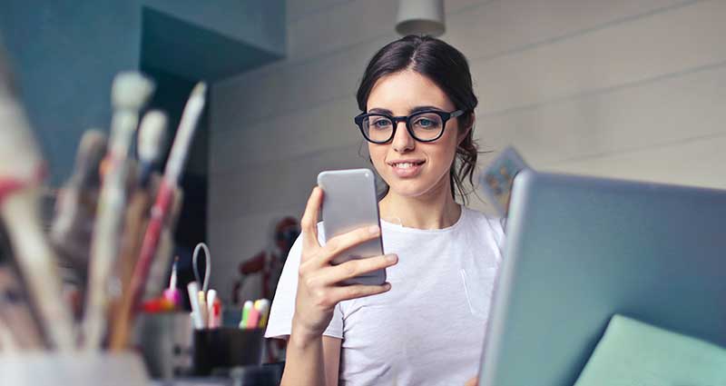 a-girl-looking-at-her-phone-smiling