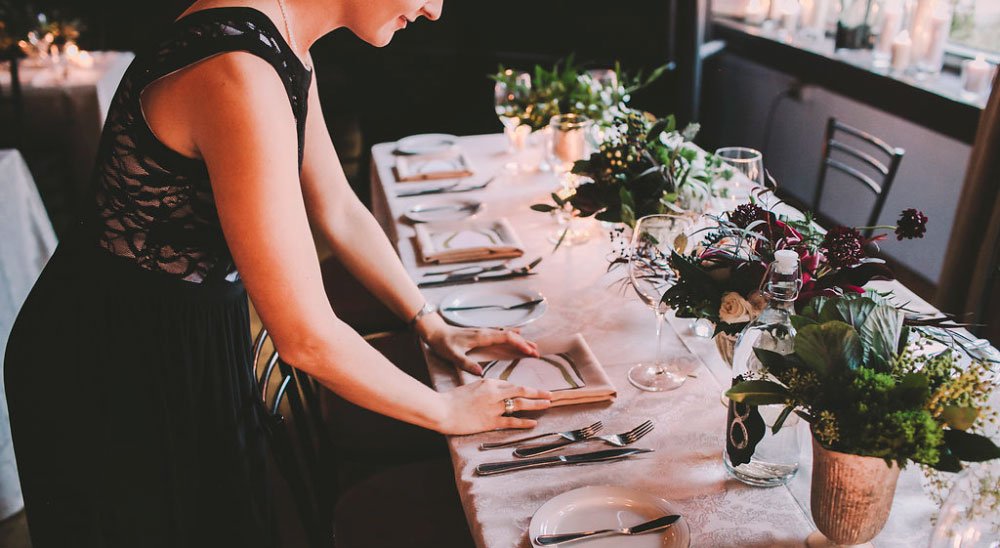 a-person-setting-up-a-table-with-plates