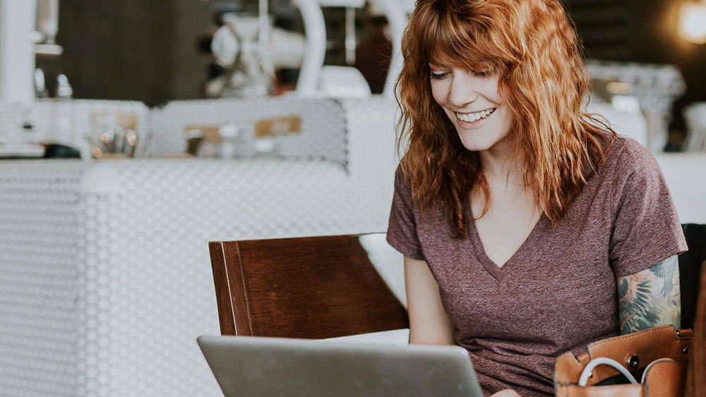 a-woman-looking-at-her-computer-smiling