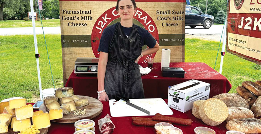 a-girl-working-a-farmers-market-booth-for-cheese